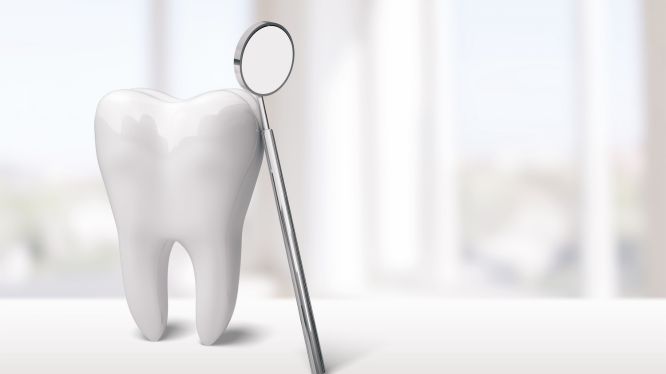 Modelo de diente blanco brillante junto a un espejo dental sobre fondo claro, simbolizando revisión y diagnóstico para rehabilitación dental en clínica especializada